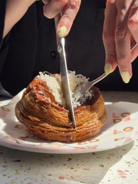 A layered pastry being cut on a Lode plate