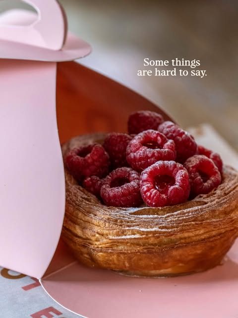 A raspberry pastry on pink paper